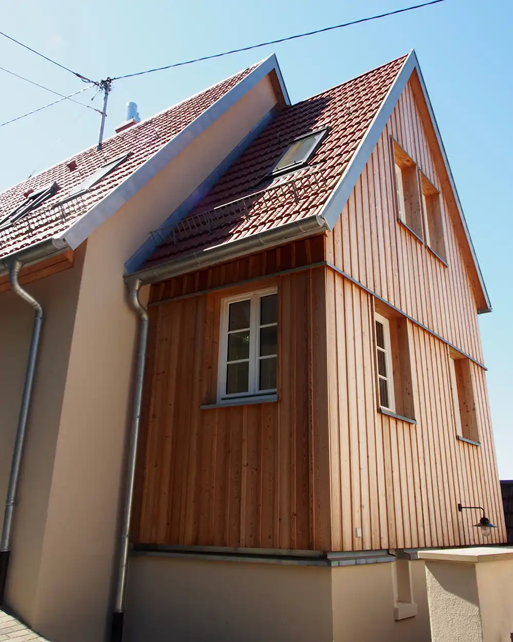 Modernisiertes Haus mit Holzfassade und Anbau