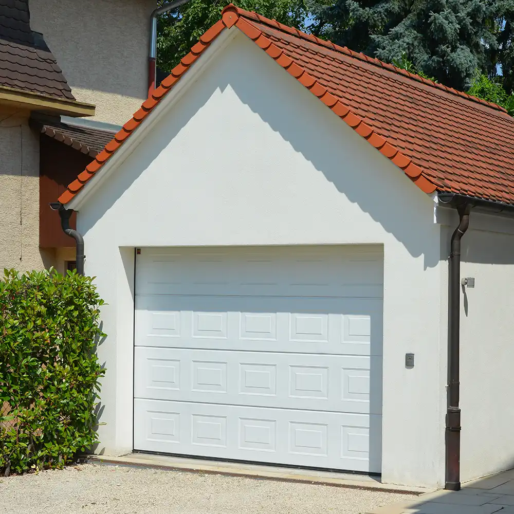 Beton-Garage mit Automatik-Tor, Satteldach, Dachrinne, Wasserfangkasten und Regenfallrohr in der Hauszufahrt